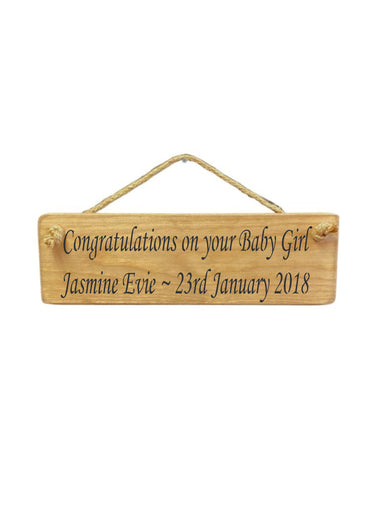 30cm x 10cm, Solid wood decorative personalised baby sign, handmade in the UK by Austin Sloan with a personalised congratulations baby girl quote "Congratulations on your Baby Girl Jasmine Evie ~ 23rd January 2018" in a natural wood colour