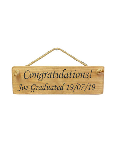 30cm x 10cm, Solid wood decorative personalised graduation sign, hand made in the UK by Austin Sloan with a personalised congratulations quote "Congratulations! Joe Graduated 19/07/19" in a natural wood colour