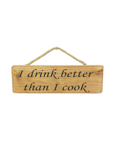 30cm x 10cm, Solid wood decorative kitchen sign, handmade in UK by Austin Sloan with a humorous quote "I drink better than I cook" in a natural wood colour