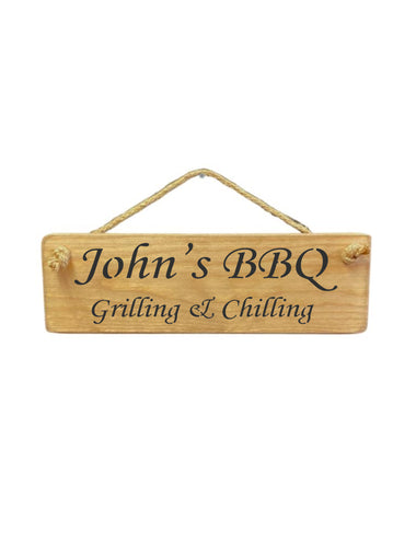 30cm x 10cm, Solid wood decorative personalised garden sign, handmade in the UK by Austin Sloan with a personalised quote "John's BBQ Grilling & Chilling" in a natural wood colour