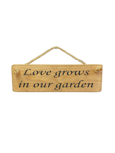 30cm x 10cm, Solid wood decorative garden sign, handmade in the UK by Austin Sloan with a loving garden quote "Love grows in our garden" in a natural wood colour