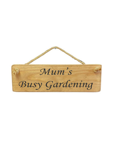 30cm x 10cm, Solid wood decorative garden sign, handmade in the UK by Austin Sloan with a gardeners quote "Mum's Busy Gardening" in a natural wood colour
