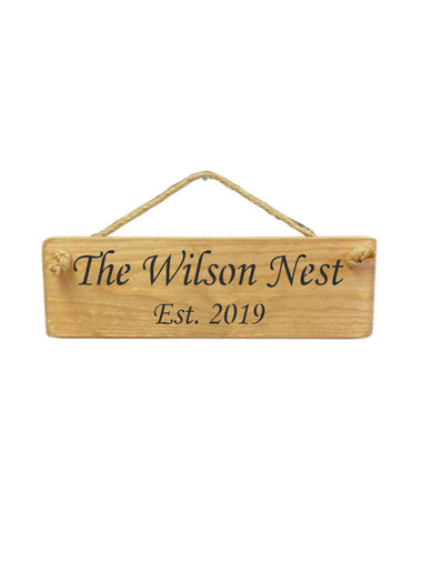30cm x 10cm, solid wood decorative personalised house sign, handmade in the UK by Austin Sloan with a personalised quote "The Wilson Nest Est. 2019" in a natural wood colour