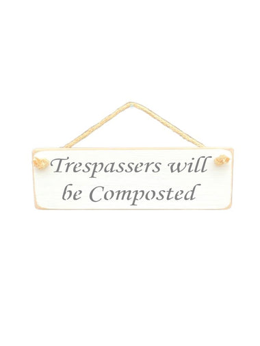 30cm x 10cm, solid wood decorative garden sign, handmade in the UK by Austin Sloan with a humorous quote "Trespassers will be Composted" in a antique white colour