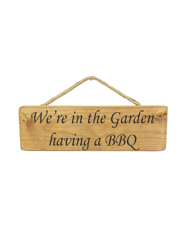 30cm x 10cm, Solid wood decorative garden sign, handmade in the UK by Austin Sloan with a bbq lovers quote "We're in the Garden having a BBQ" in a natural wood colour