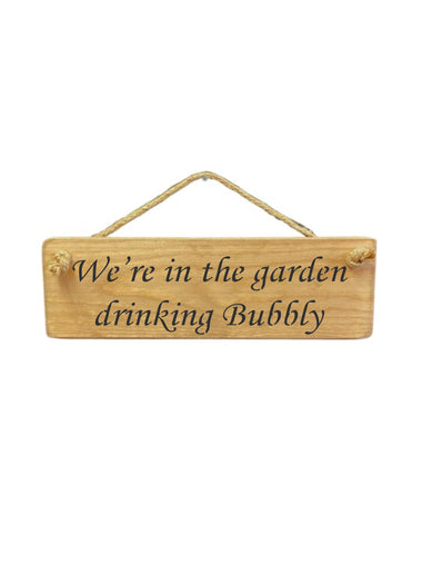 30cm x 10cm, Solid wood decorative garden sign, handmade in the UK by Austin Sloan with a alcohol lovers quote "We're in the garden drinking Bubbly" in a natural wood colour
