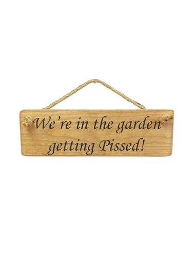 30cm x 10cm, Solid wood decorative garden sign, handmade in the UK by Austin Sloan with a alcohol lovers quote "We're in the garden getting Pissed!" in a natural wood colour