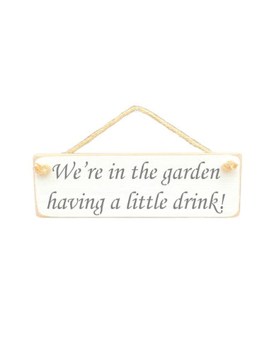 30cm x 10cm, Solid wood decorative garden sign, handmade in the UK by Austin Sloan with a alcohol lovers quote "We're in the garden having a little drink!" in a antique white colour