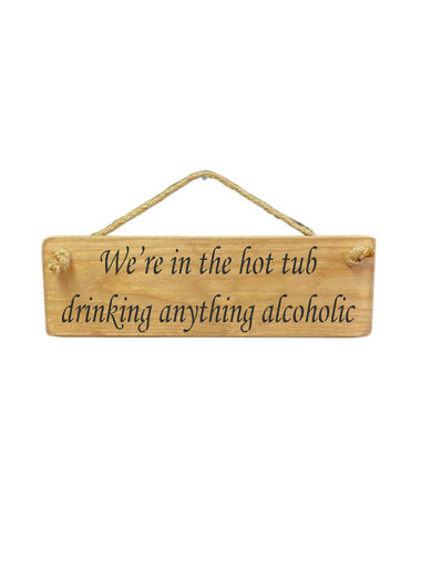 30cm x 10cm, Solid wood decorative hot tub sign, handmade in the UK by Austin Sloan with a alcohol lovers quote "We're in the hot tub drinking anything alcoholic" in a natural wood colour